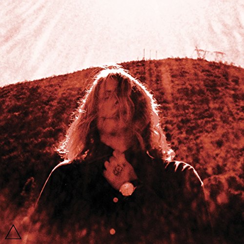 Red-toned portrait of a person with long hair, looking downward.