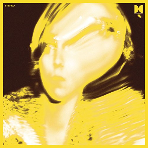 Yellow vinyl record cover featuring a blurred, close-up portrait.