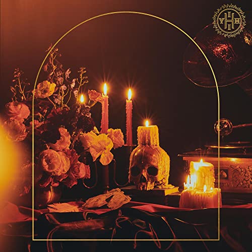 Dark still life with lit candles, skull, flowers, and gramophone.