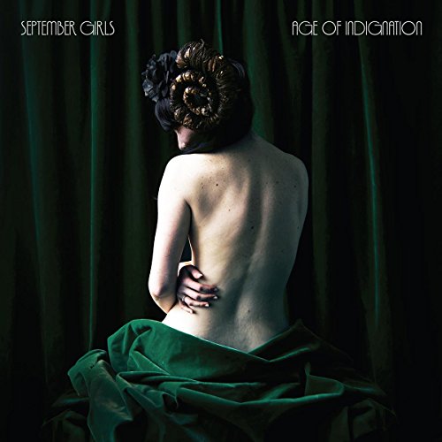 Back of a nude woman with a floral headpiece against green drapery.