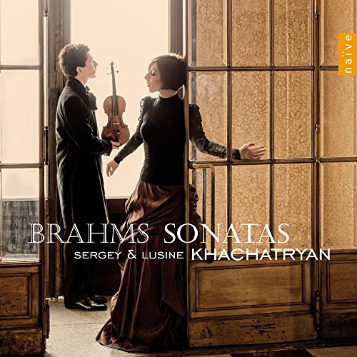 A man holding a violin and a woman standing in a doorway.