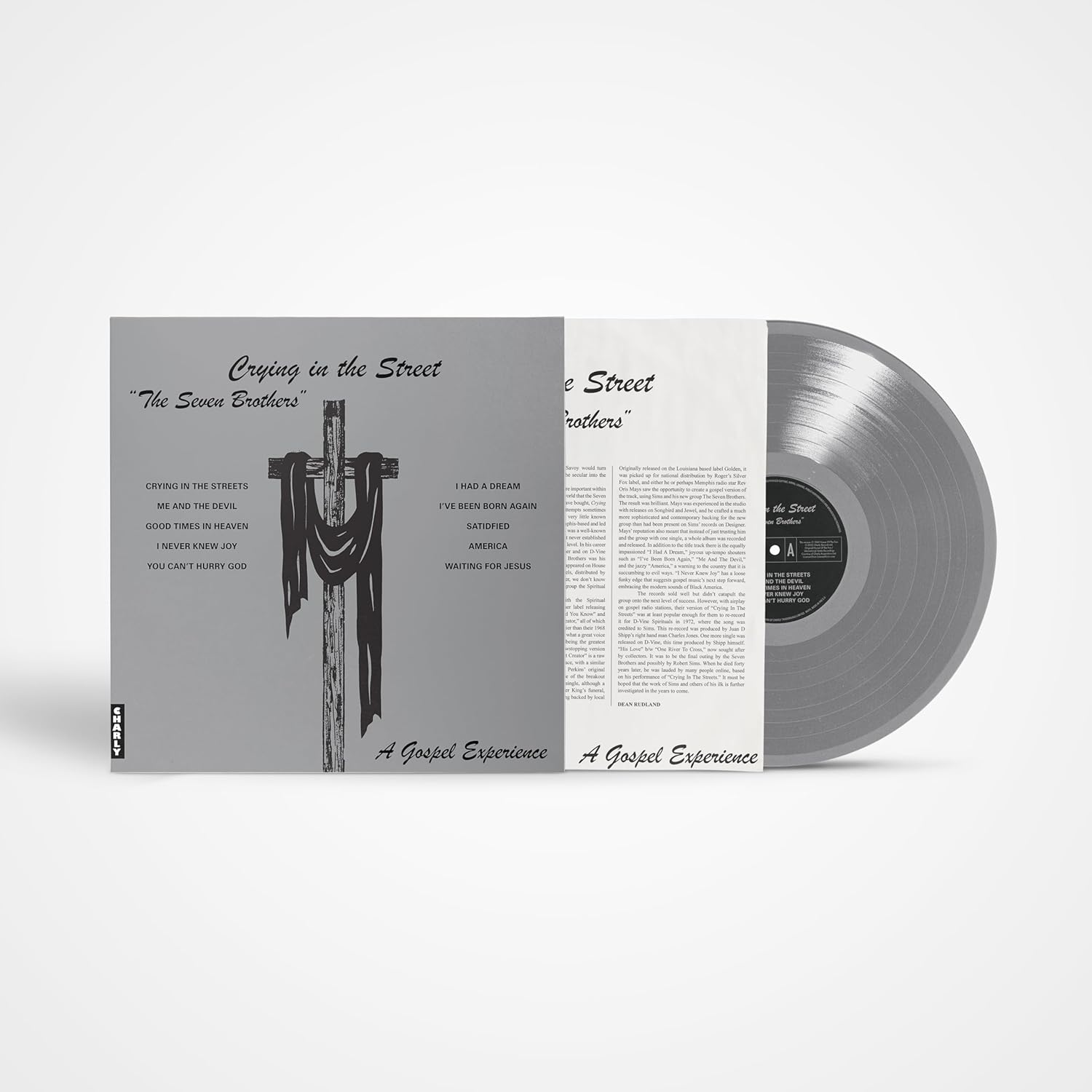 Vinyl record with album cover depicting a cross and text, grayscale.