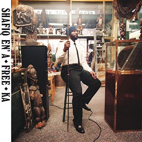 Shafiq Husayn album cover featuring a man in a shop surrounded by artifacts.