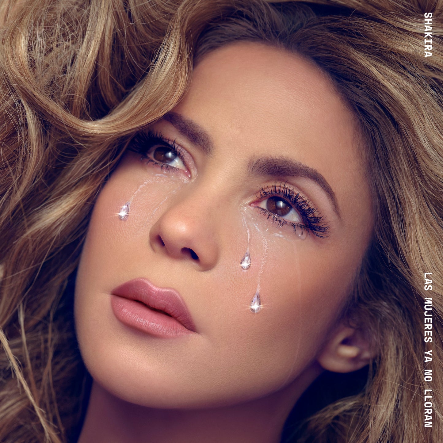 Shakira album cover, close-up portrait with tear-like droplets.