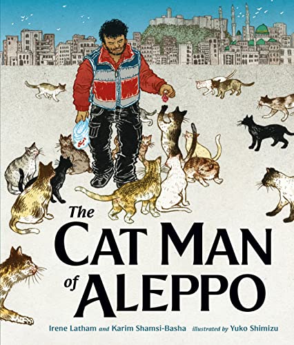 A man in a red vest stands surrounded by many cats in front of Aleppo.