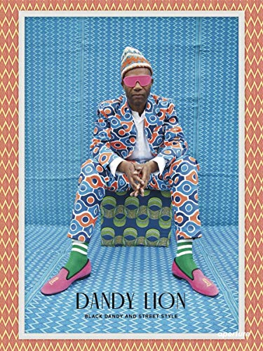 Man in vibrant patterned suit sits on a patterned cube.