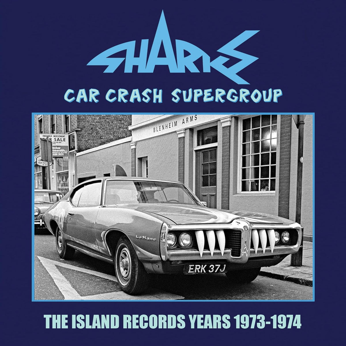 CD cover: black and white photo of a damaged car in front of buildings.