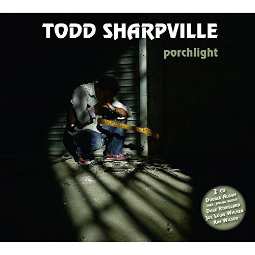 CD cover: man playing guitar on a porch, dark and shadowed.