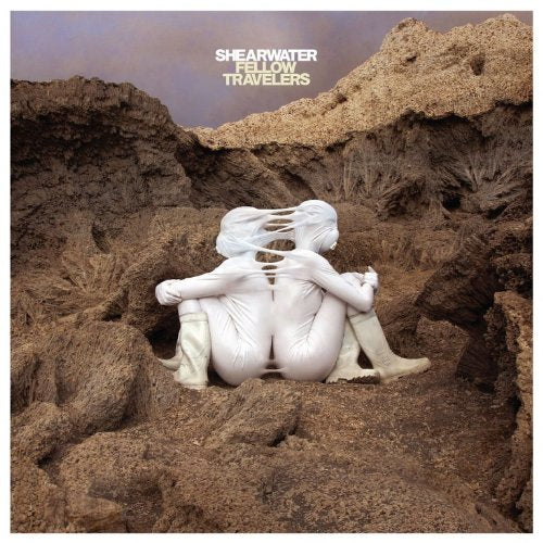 Album cover: two figures embracing amidst a rocky, textured landscape.