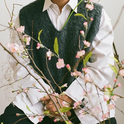 CD cover with a person in a sweater and cherry blossoms.