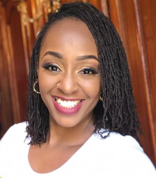 Close-up of a smiling Black woman with locs and gold earrings.