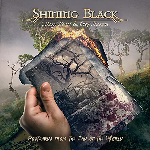 CD cover art: hand holding a burning postcard in a desolate landscape.