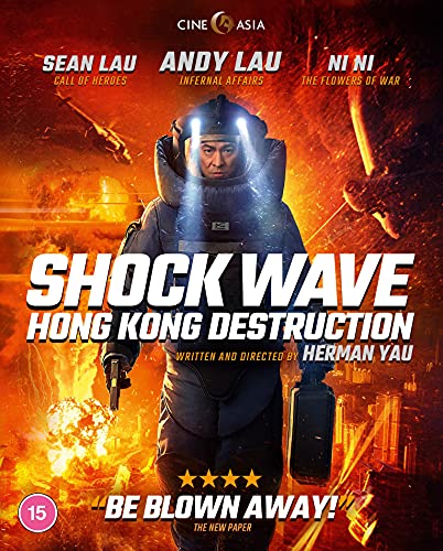 A bomb disposal expert in protective gear stands before a fiery explosion in Hong Kong.