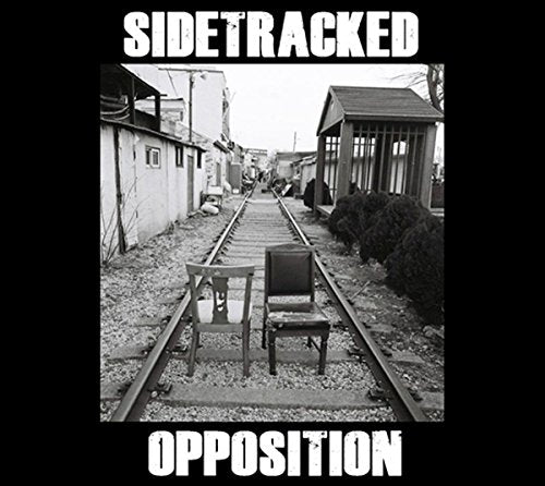 Black and white album cover with train tracks and two chairs.
