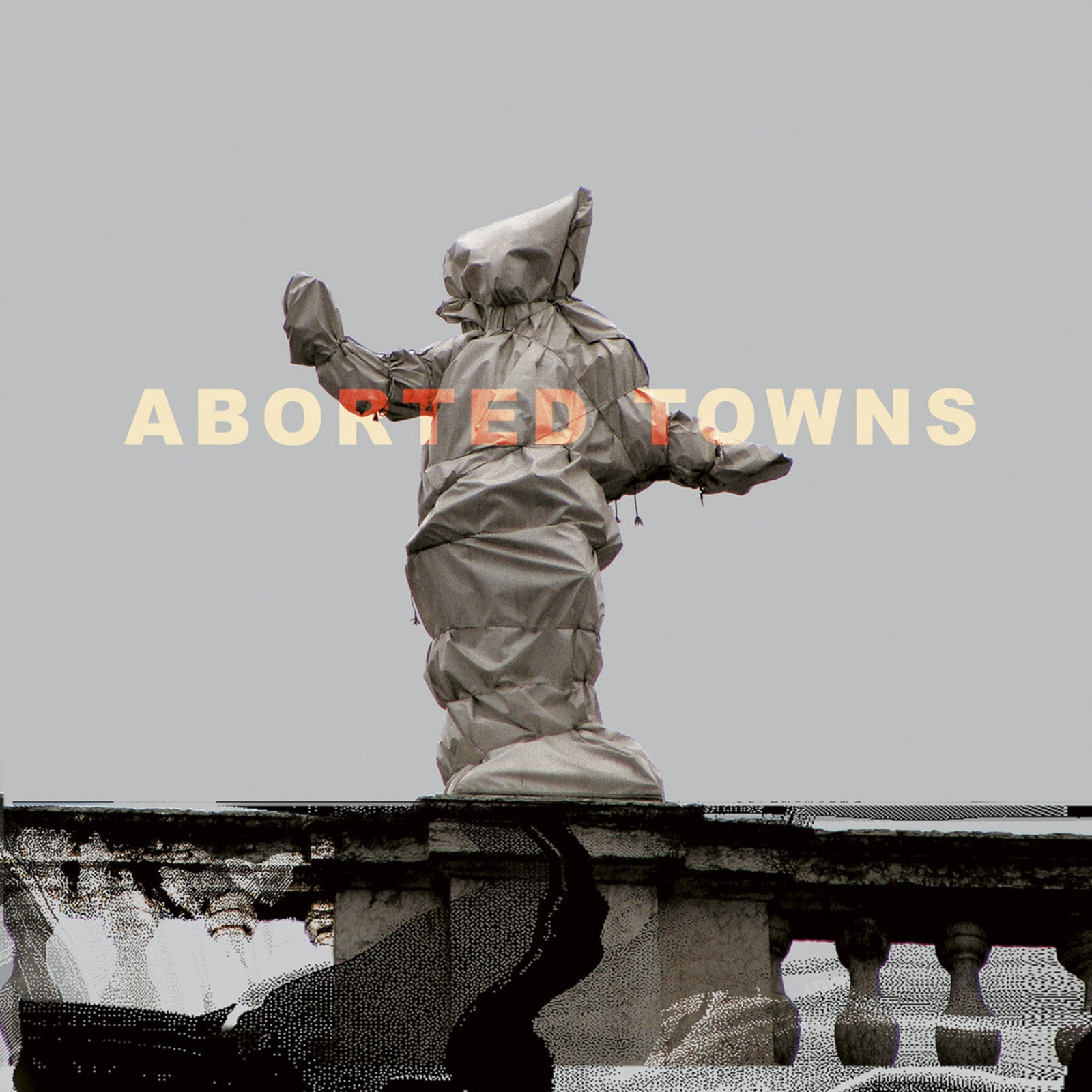 Hooded figure statue on a rooftop, album cover for "Aborted Towns.