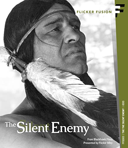 Black and white close-up of an Indigenous man wearing a headband and feathers.
