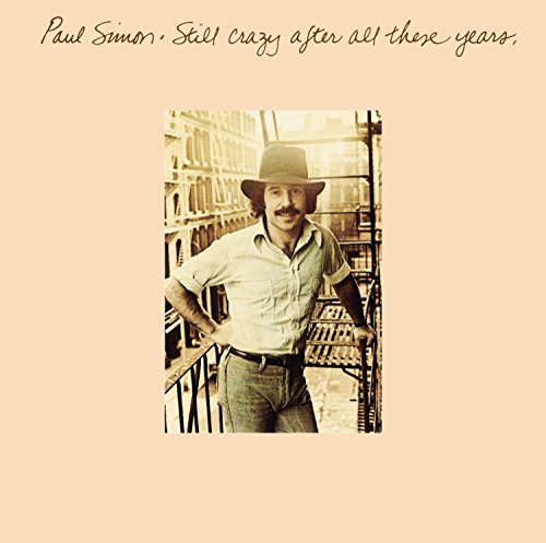 Paul Simon in a hat and light shirt, album cover art.