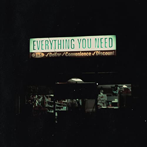 Nighttime view of a brightly lit store sign reading "EVERYTHING YOU NEED".