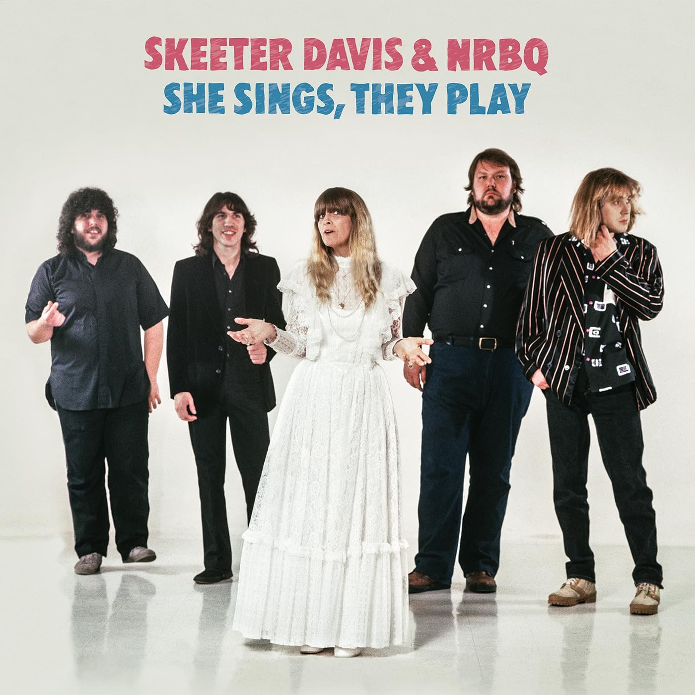 Skeeter Davis and NRBQ pose in vintage clothing on a pale background.