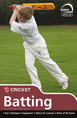 A young boy in white cricket gear swings a yellow cricket bat on grass.