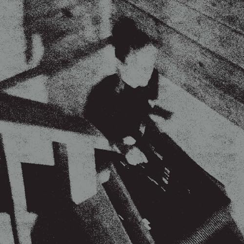 Black and white, grainy image of a person with obscured face.