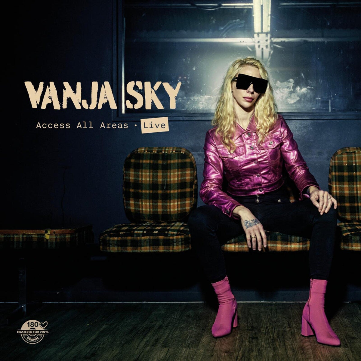 Vanja Sky album cover: artist in pink jacket seated on chair.