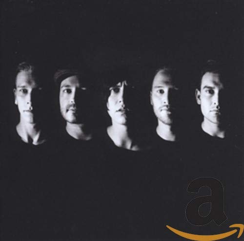 Black and white portrait of five men against a dark background.