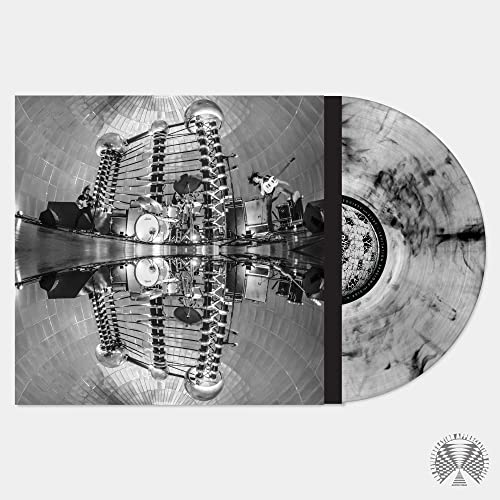 Black and white vinyl record next to its cover featuring a band performing live.