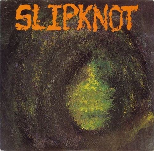 Slipknot album cover: textured dark background with orange lettering.