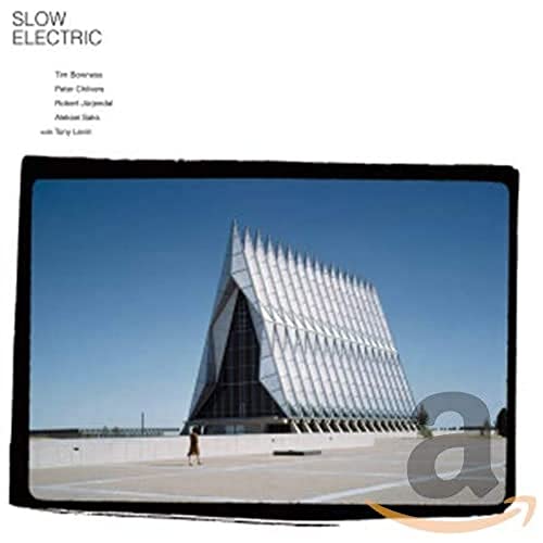 CD cover featuring a modern triangular building and a person walking on a plaza.