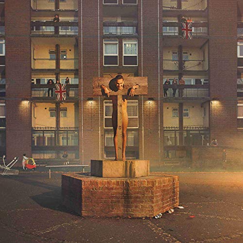 Statue of a person on a cross in front of a brick building.