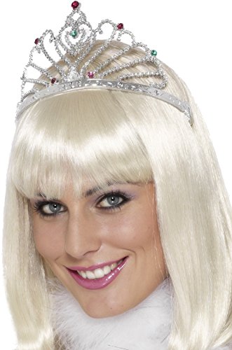 A woman wears a silver tiara with red and clear gems on her head.