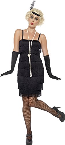 Woman wearing a black 1920s flapper costume, gloves, headband, and pearl necklace, posing on a white background.