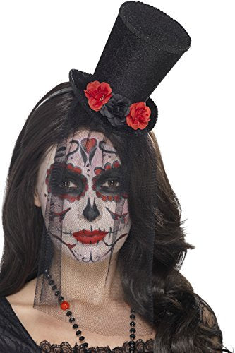 "Woman with sugar skull face paint wearing a black top hat adorned with red flowers."