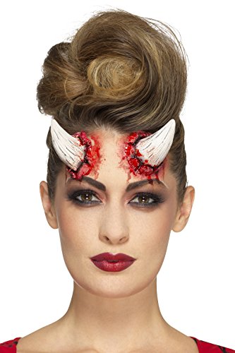 Ivory devil horns prosthetic with simulated wounds on a woman’s forehead.