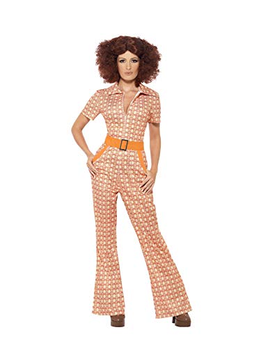 A woman with a brown afro wig wearing a patterned 70s-style jumpsuit with orange belt.