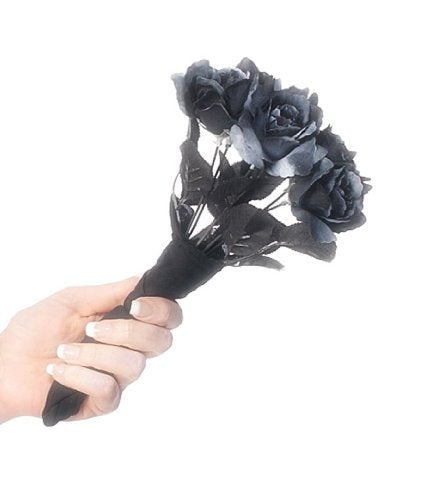 A woman in a white wedding dress holds a bouquet of black roses.
