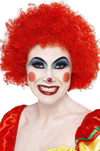 A person dressed as a clown, wearing a bright red curly wig and painted-on smile.
