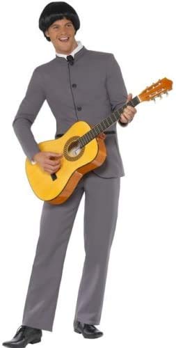 Man wearing a grey 1960s-style suit and bowl-cut wig, playing an acoustic guitar.