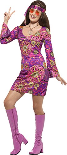 A woman in a multicolored hippie costume, including a dress, boots, and headband, poses playfully.