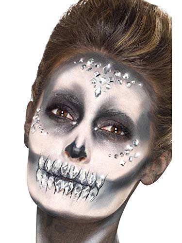 Person with skull makeup and sparkling jewel face gems applied.