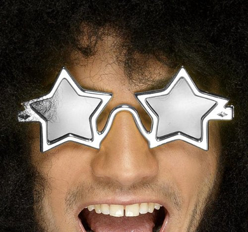 A man wearing silver star-shaped sunglasses and a curly black wig, laughing.