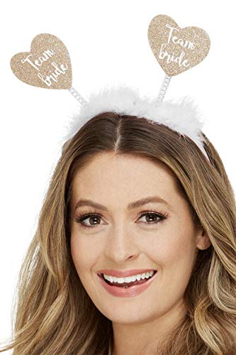 Gold heart "Team Bride" boppers on a white fluffy headband, worn by a woman.