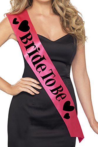 Woman wearing a black dress and a pink "Bride To Be" sash with black hearts.