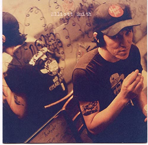 Elliott Smith wearing a baseball cap and t-shirt in a double-exposed photograph.