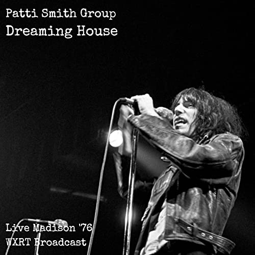 Patti Smith performing live with a microphone, black and white image.
