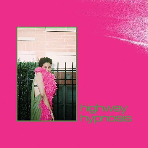 A person in a pink feather boa stands before a fence on a pink background.