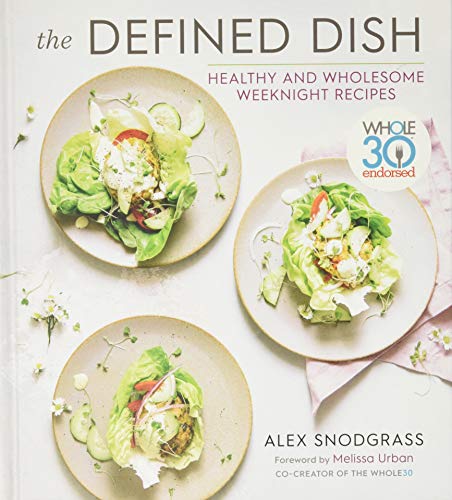 Cookbook cover featuring salads, text “The Defined Dish” and “Whole30 endorsed”.