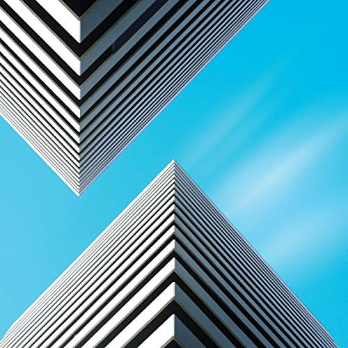 The alt text for the image is: "Two white, angled skyscrapers against a bright blue sky."