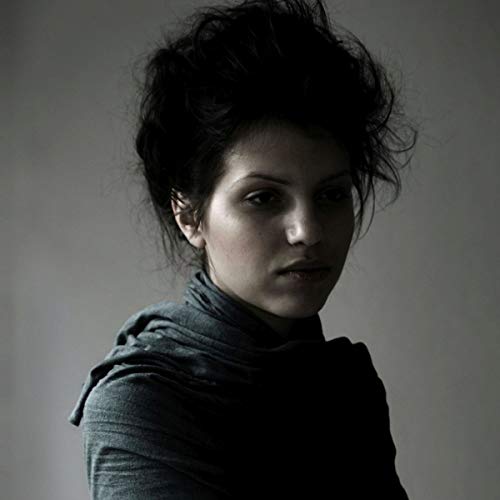 Close-up portrait of a woman with dark hair and a neutral expression.